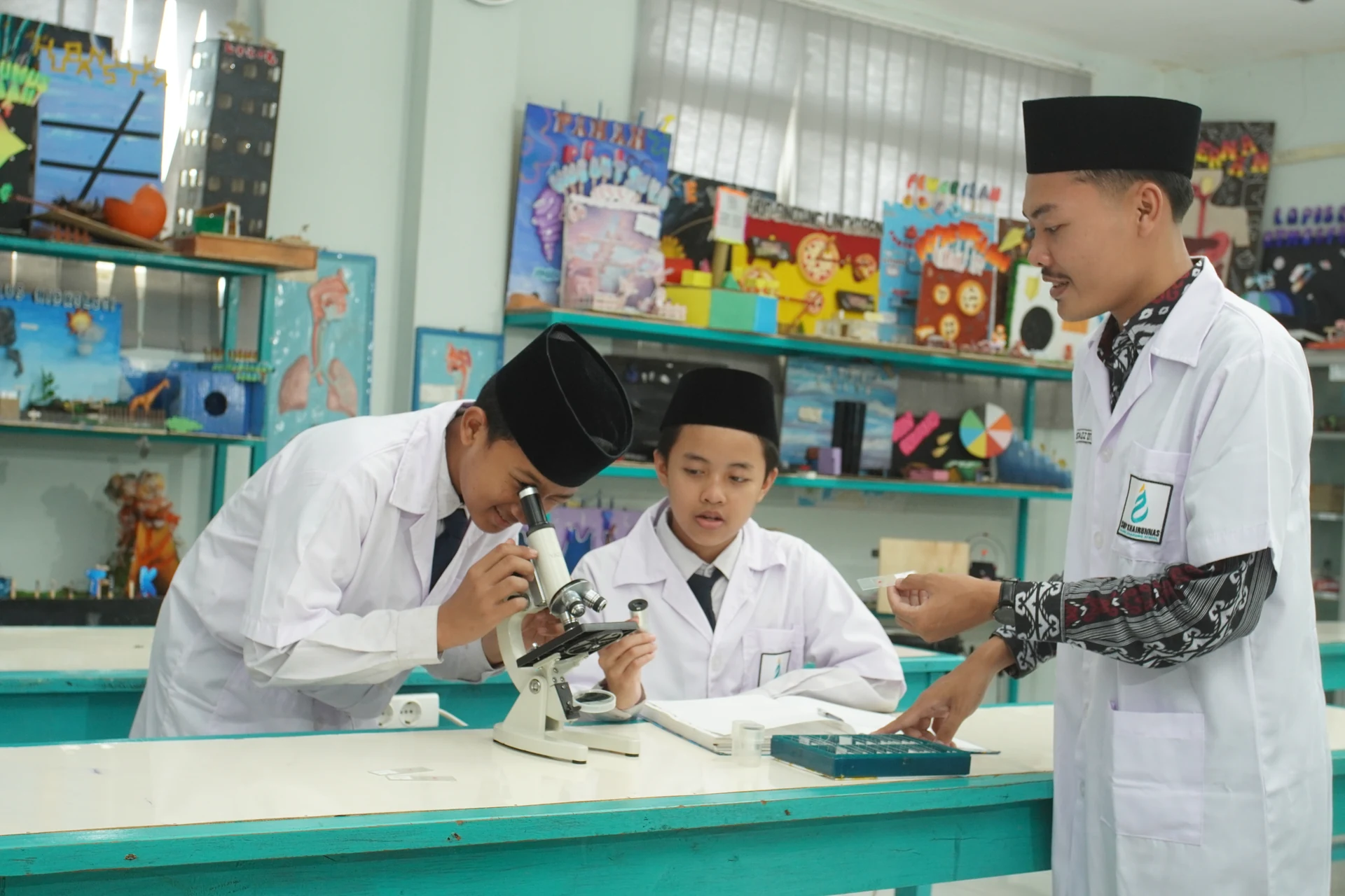 Santri putra mengamati preparat dengan mikroskop di laboratorium IPA.
